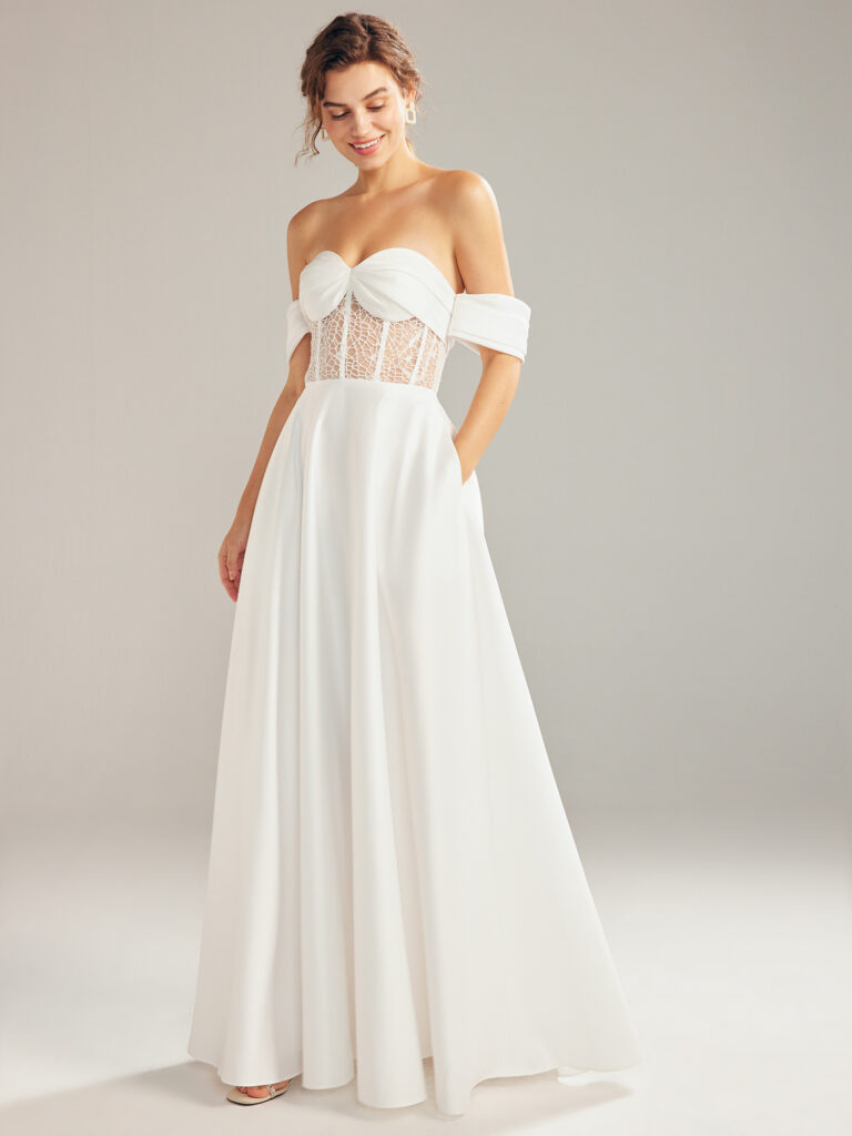 A bride wears a white wedding dress and smiles.